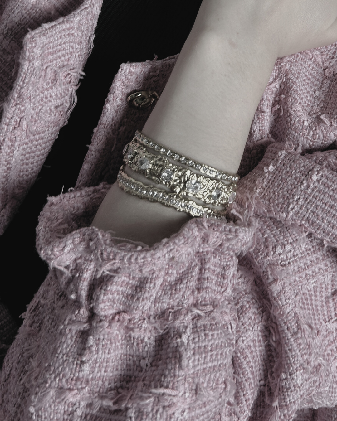 Close-up of a textured fabric garment with a silver bracelet on a mannequin arm.