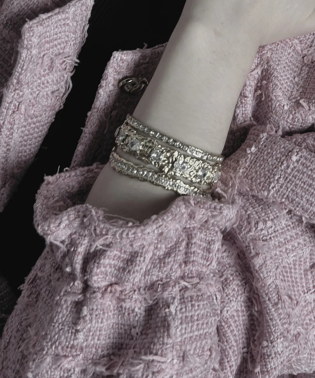 Close-up of a textured fabric garment with a silver bracelet on a mannequin arm.