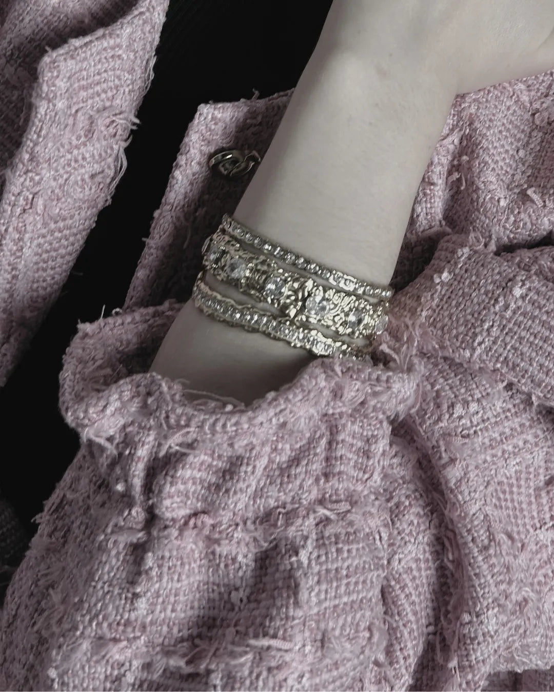 Close-up of a textured fabric garment with a silver bracelet on a mannequin arm.